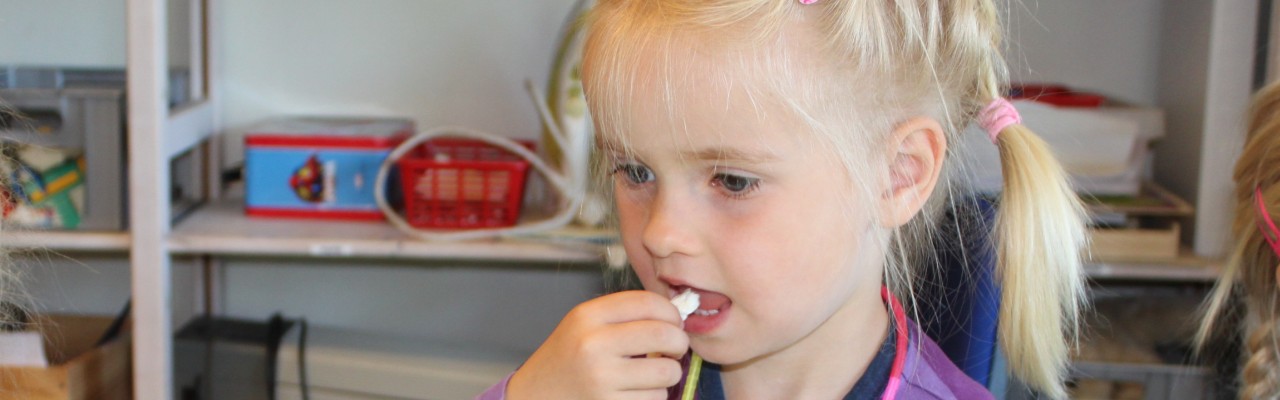 Girl taking a bite of fish